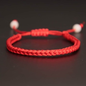 Bracelet en corde rouge tressée à la main sur fond noir