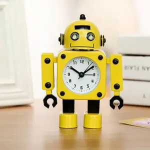 Horloge d'alarme en forme de robot jaune sur meuble marron avec livres