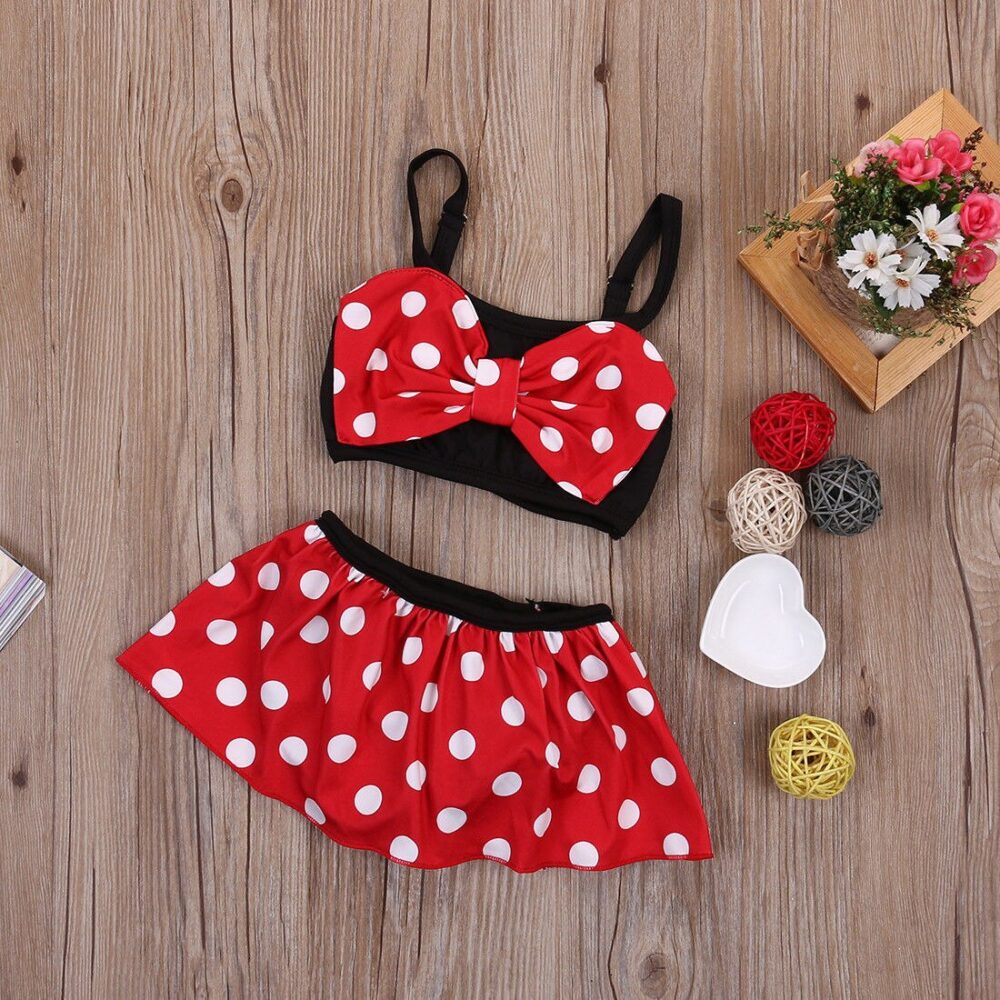 Maillot de bain fille deux pièces avec noeud de papillon en rouge style minnie sur fond en bois