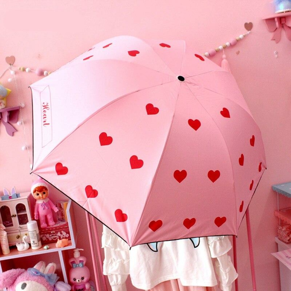 Parapluie rose à motif cœur rouge pour fille. Bonne qualité et très pratique.