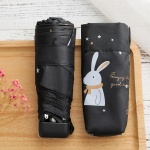 Mini parapluie de poche pour enfant avec lapin blanc sur parapluie noir sur une table en bois