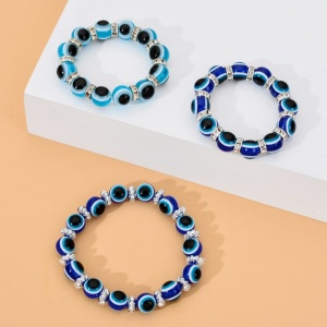 Bracelet perle en verre élastique pour enfant bleu et noir sur etagère blanche et orange