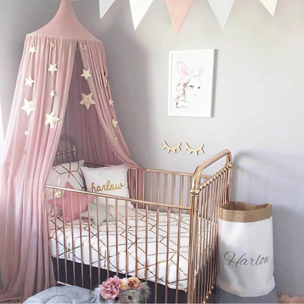 Tipi tête de lit pour bébés rose avec étoiles en blanc avec lit de bebe en rotin et des draps blancs