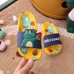Tongs crocodile pour enfant jaune et bleu avec des motifs crocodile dur la main d'une personne