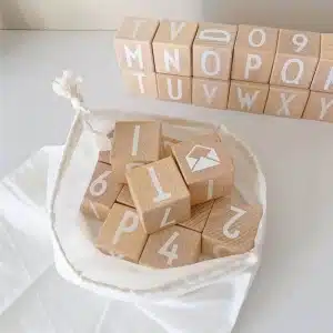 Jouet de l'alphabet en bois à empiler dans un sac blanc sur une table blanche