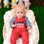 Poupée petite-fille avec vetements rouges sur un manteau blanc