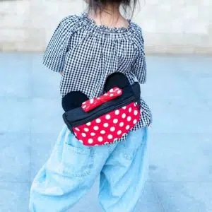 Sacoche banane avec oreilles de Mickey et Minnie rouge, noir et blanche sur le dos d'une fille