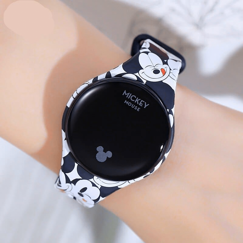 Une main blanche avec une montre connectée pour enfant mickey mouse bleu et blanche