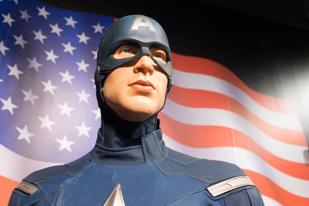 La statue de Captain America du musée Tussaud devant un drapeau de l'Amérique
