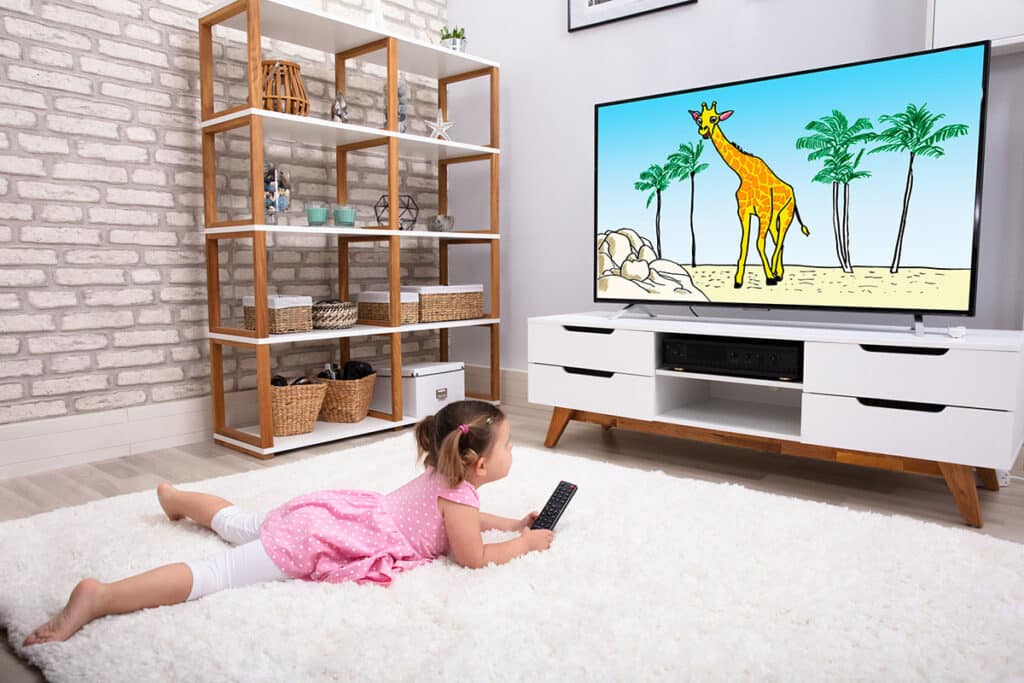 Petite fille en train de regarder un dessin animé sur la télé