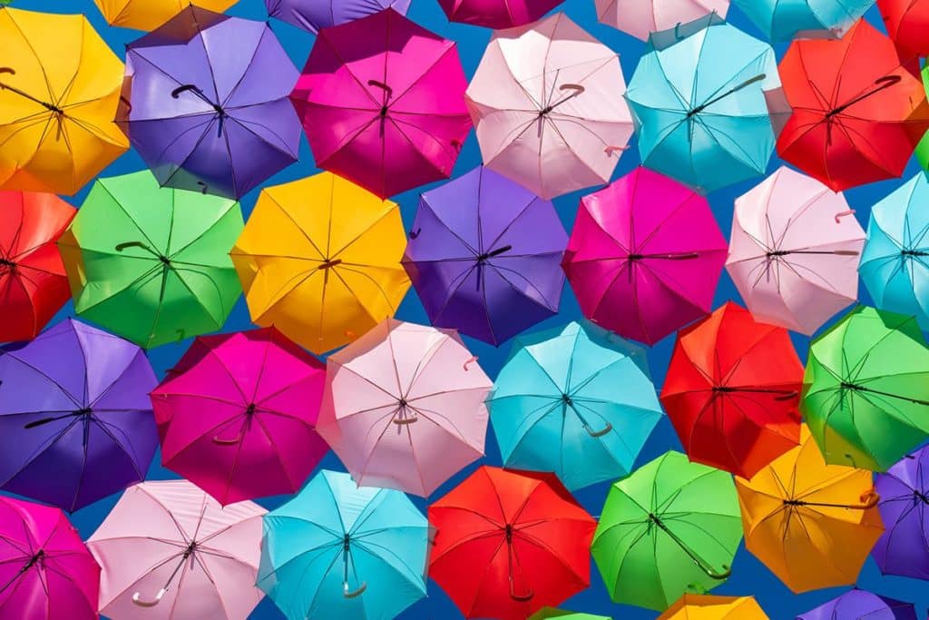 Un arc en ciel de parapluies enfants de toutes les couleurs.