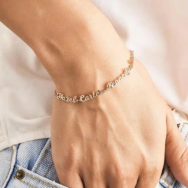 Bracelet personnalisé avec un à trois noms doré sur le poignée d'une femme