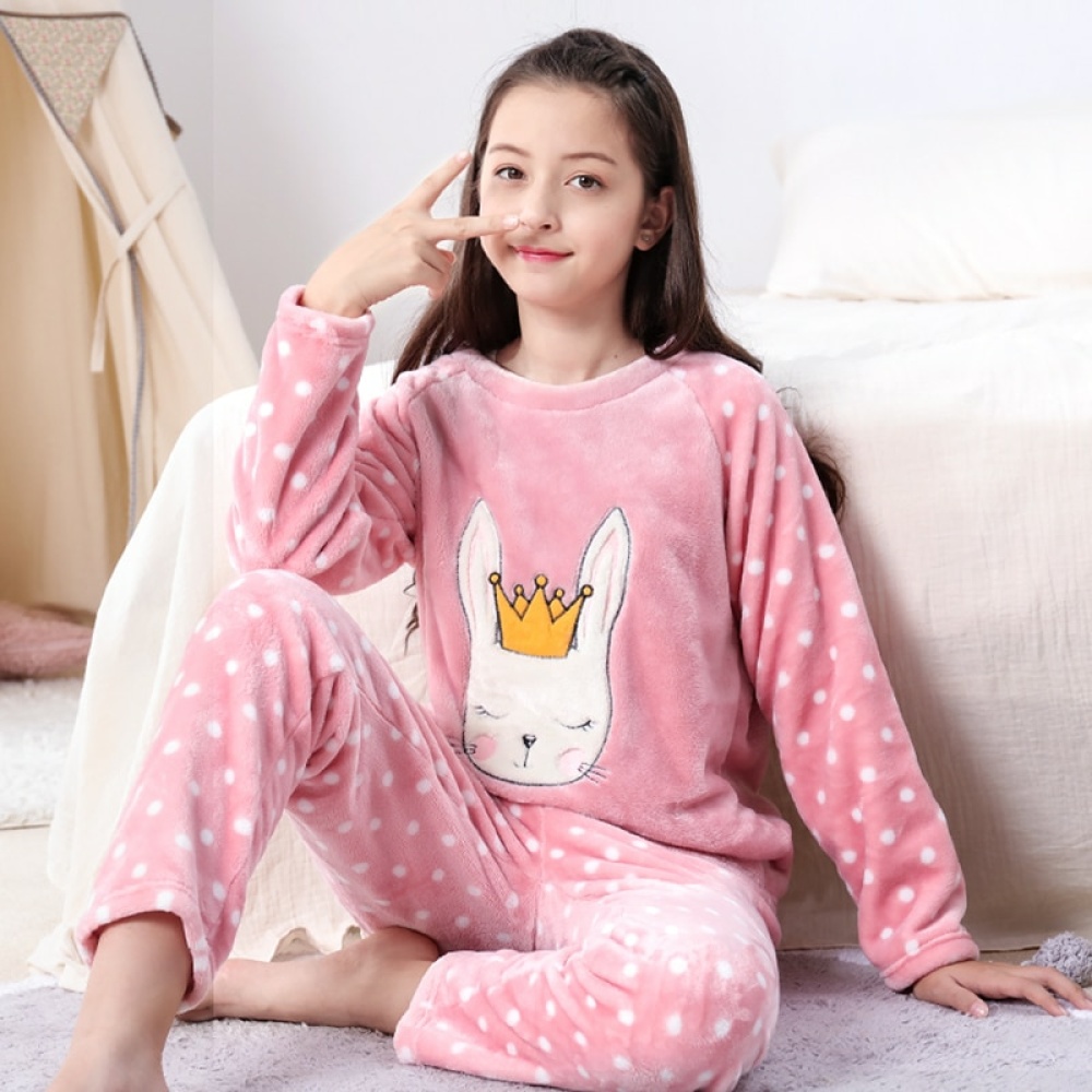 Une fille qui porte le pyjama polaire avec un motif lapin à petit poits blanc dans un lit