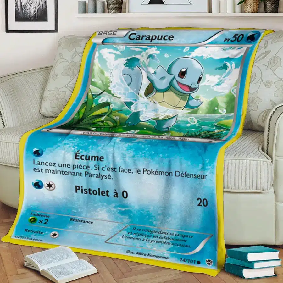 Plaid carte Pokémon Carapuce bleu sur un canapé avec des livres