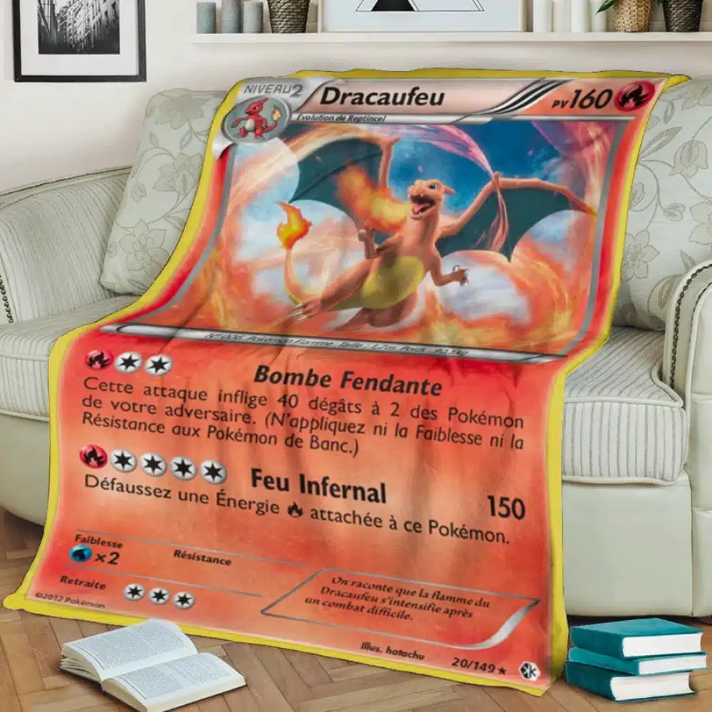 Plaid carte Pokémon Dracaufeu pour enfants orange sur un canape avec des livres