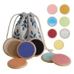 ensemble de 14 pièces rondes et colorées aux textures différentes posées à côté d'un sachet de rangement en tissu