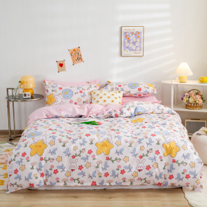 Chambre avec un lit au centre, une couette rose à motifs et des éléments de décoration