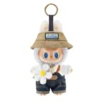 peluche Labubu blanche avec un chapeau beige, salopette en jean et fleur blanche,