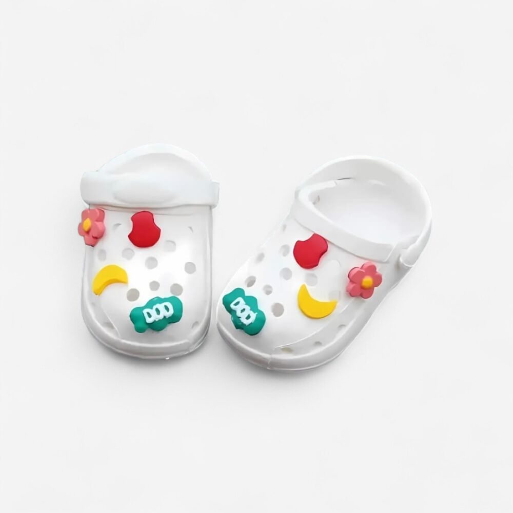 Mini sabots blancs pour poupée Labubu, style Crocs avec motifs ludiques qui les décorent, sur fond blanc
