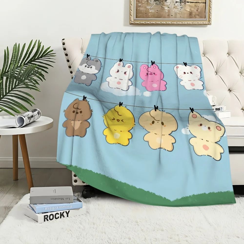 Plaid pour enfant au style kawaii avec des effigies Skzoo des Stray kids sur un canapé