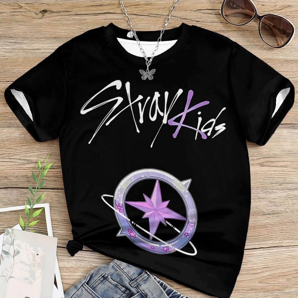 Photo flatlay d'un t-shirt noir pour enfant imprimé Stray Kids avec le dessin d'une boussole