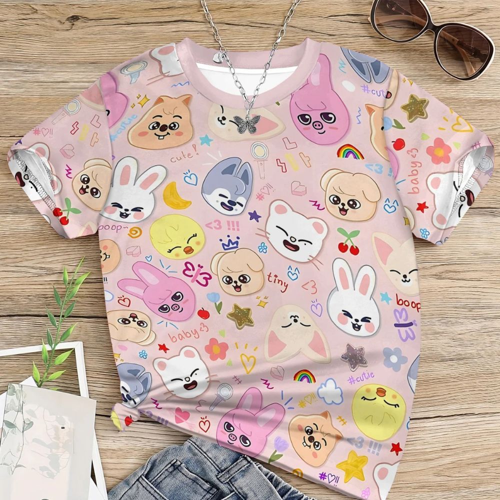 Photo Flatlay d'un t-shirt pour enfant à motif kawaii à l'effigie du groupe Stray Kids dans un coloris rose pastel