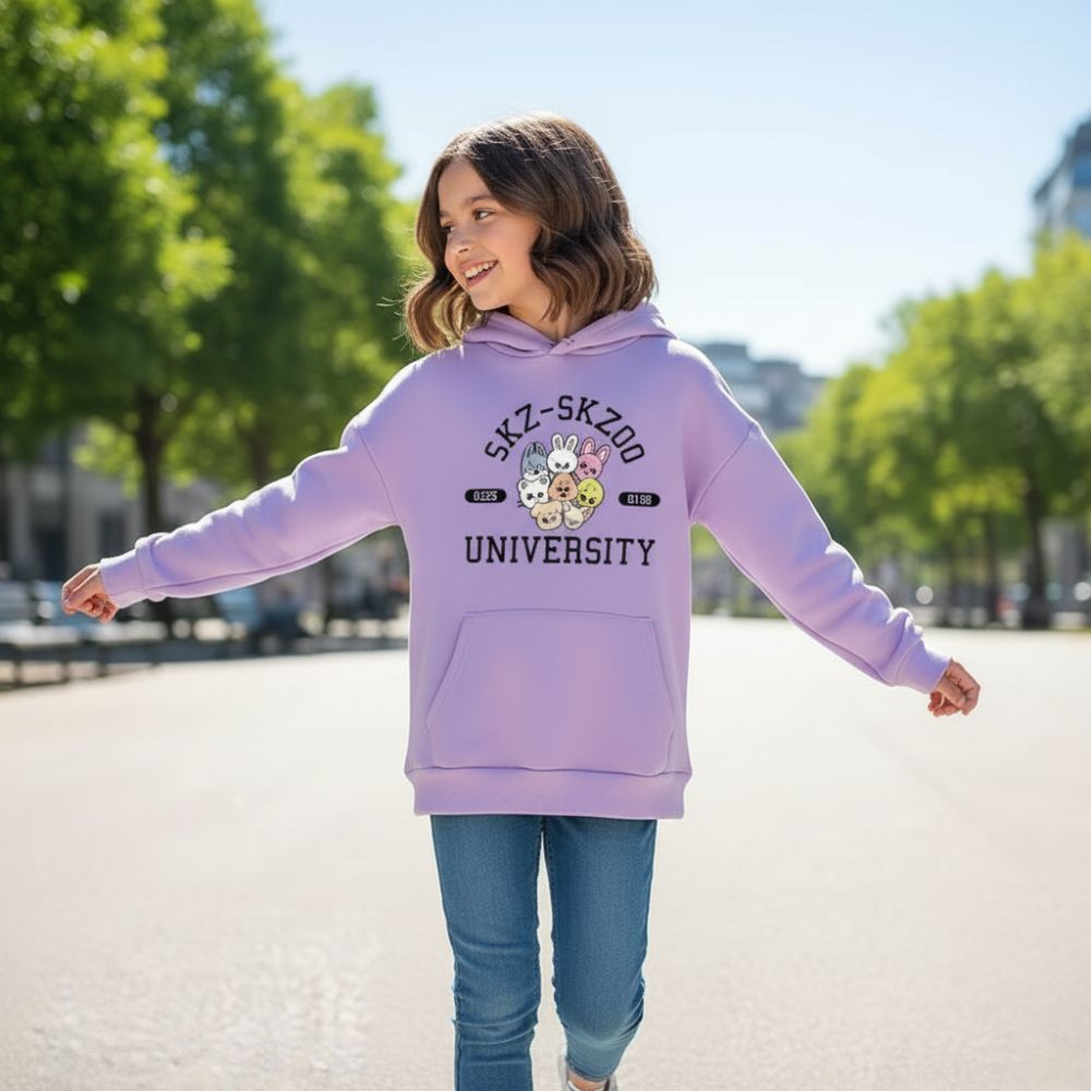 Petite fille portant un sweatshirt violet pastel à l'effigie des Stray Kids dans un parc