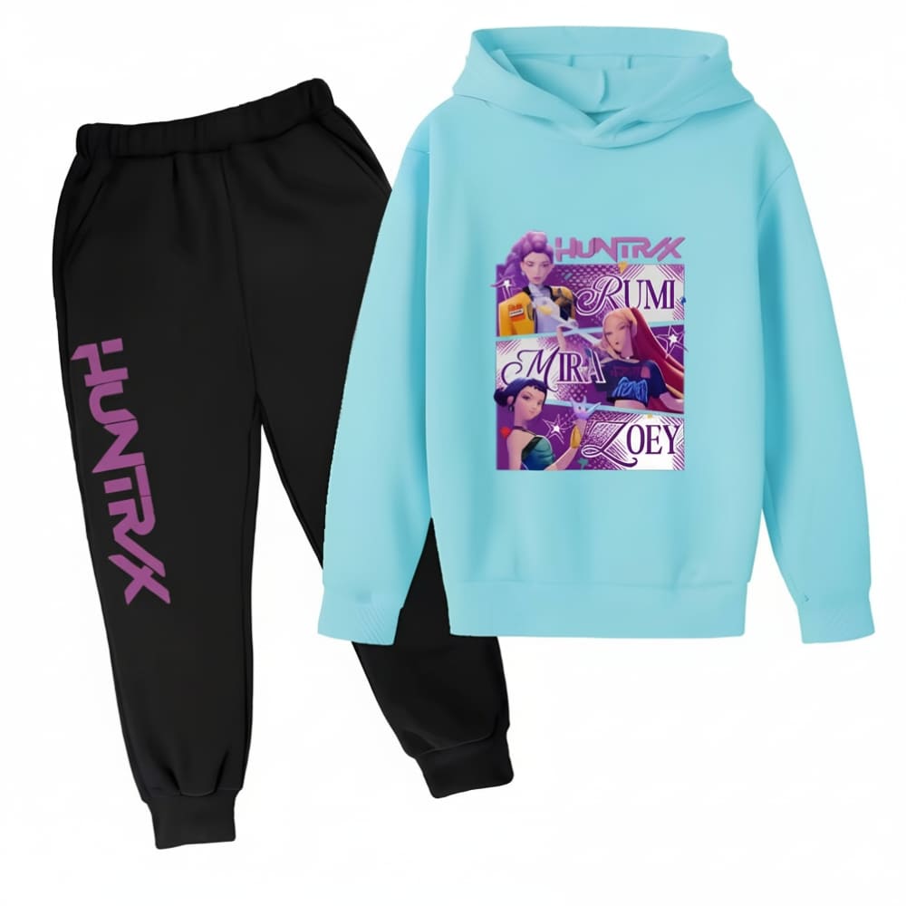 Ensemble jogging K-pop Demon Hunters bicolore avec un pantalon noir et l'inscription "Huntrix" en majuscules violettes sur une jambe et un sweat à capuche bleu clair avec un motif représentant les 3 héroïnes et leurs prénoms. Sur fond blanc.