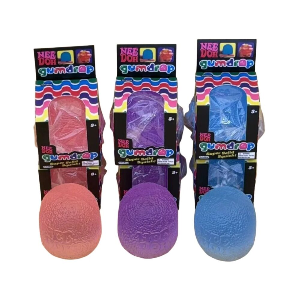 3 boites de needoh alignées avec devant le Needoh coloré en forme de gumdrop, un rose, un violet et un bleu
